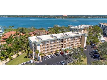 Beautiful condo building with lush landscaping and ample parking, near bay and other residential buildings at 8625 Midnight Pass Rd # 305B, Siesta Key, FL 34242