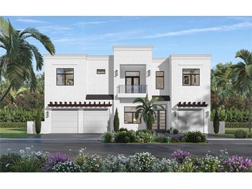 Stunning two-story modern home boasting a sleek design, private balcony, two-car garage, and vibrant landscaping at 1879 Hibiscus St, Sarasota, FL 34239