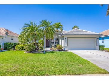 Charming single-story home with lush landscaping, beautiful palm trees, and a well-manicured lawn at 2871 Royal Palm Dr, North Port, FL 34288