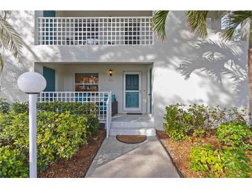 Picture perfect condo entrance with meticulous landscaping, outdoor seating, and a welcoming entrance at 321 108Th W St # 120, Bradenton, FL 34209