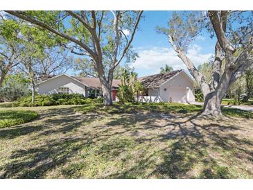 Charming single-story home with lush landscaping and mature trees, offering a serene and private setting at 4965 Marsh Field Rd, Sarasota, FL 34235