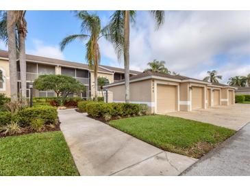 Well-maintained condo building with attached garages and mature landscaping at 5240 Hyland Hills Ave # 1426, Sarasota, FL 34241