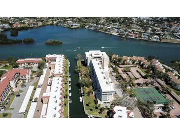 Stunning aerial view of waterfront condos with boat docks, lush landscaping, and serene water views at 1250 N Portofino Dr # 201, Sarasota, FL 34242