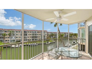 Relaxing screened-in balcony with ceiling fan overlooking a canal with boats and views of the condos at 1250 N Portofino Dr # 303, Sarasota, FL 34242