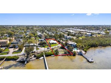 A waterfront property with a pier on a sunny day is outlined in red at 1815 Palma Sola Blvd, Bradenton, FL 34209