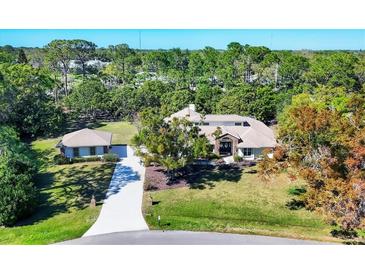 Sprawling home with an oversized driveway and lush landscaping at 4942 Hidden Oaks Ln, Sarasota, FL 34232