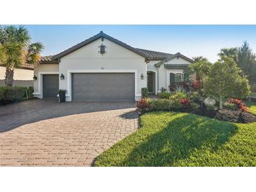 Charming single-story home featuring a brick driveway, mature landscaping, and a spacious three-car garage at 5203 Rushmere Ct, Palmetto, FL 34221