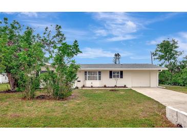 Charming one-story home with a well-maintained lawn, blue sky and lush landscaping at 610 Cumberland Rd, Venice, FL 34293