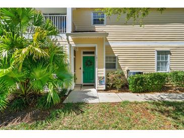 Charming condo featuring a vibrant green front door and lush tropical landscaping at 6320 Rosefinch Ct # 101, Lakewood Ranch, FL 34202