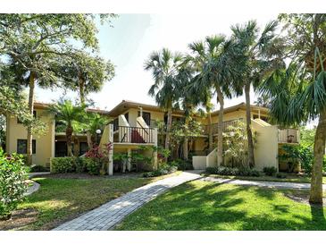 Beautiful exterior view of condos with mature landscaping and inviting walkway at 6450 Wild Oak Bay Blvd # 240, Bradenton, FL 34210