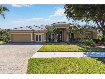 Charming single-story home with well-manicured lawn and a paver driveway leading to an attached two-car garage at 742 Shadow Bay Way, Osprey, FL 34229