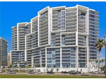 Modern condominium featuring a striking architectural design, glass balconies, and views of palm trees at 1155 N Gulfstream Ave # 708, Sarasota, FL 34236