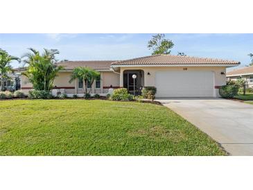 Charming single-story home with well-maintained lawn, lush landscaping, and attached two-car garage at 128 Da Vinci Dr, Nokomis, FL 34275