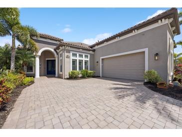 Charming home featuring a paver driveway and manicured landscaping at 14817 Secret Harbor Pl, Lakewood Ranch, FL 34202