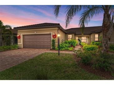 Charming single-story home featuring a tile roof, a brick driveway, and well-maintained landscaping at 17696 Northwood Pl, Lakewood Ranch, FL 34202