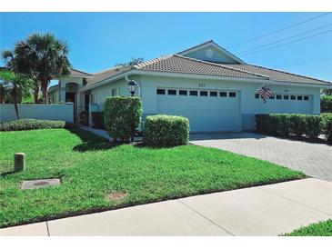 Charming single-story home with a well-manicured lawn, tile roof, and attached two-car garage at 321 Reclinata Cir, Venice, FL 34292