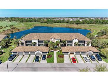 Beautiful aerial view of condo building, lake, and golf course with lush greenery and well-manicured lawns at 5577 Palmer Cir # 203, Bradenton, FL 34211