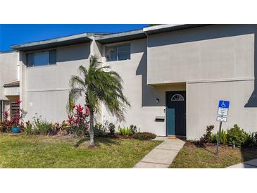 Charming townhome with a well-manicured lawn and tropical landscaping, inviting entrance and designated handicap parking at 6881 Whitman Way, Sarasota, FL 34243