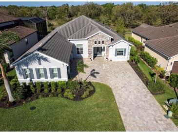 Stunning aerial view of home featuring landscaped yard and paver driveway at 7095 Tamworth Pkwy, Sarasota, FL 34241