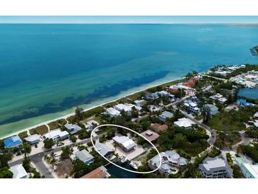 Breathtaking aerial view of the charming waterfront property with lush greenery and stunning ocean backdrop at 807 S Bay Blvd, Anna Maria, FL 34216