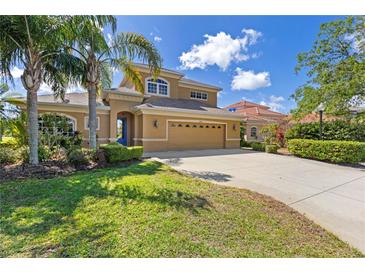 Stunning two-story home with a well-manicured lawn, tall palm trees and a large driveway leading to a spacious garage at 12420 Aster Ave, Bradenton, FL 34212