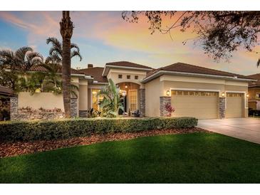 Beautiful, upgraded exterior featuring a manicured lawn and lush tropical landscaping at 13414 Goldfinch Dr, Lakewood Ranch, FL 34202