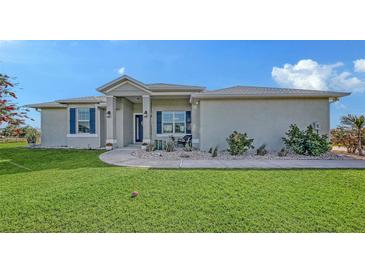 Charming single-story home featuring a manicured lawn, blue shutters, and decorative landscaping at 13904 Gettis Lee Rd, Parrish, FL 34219