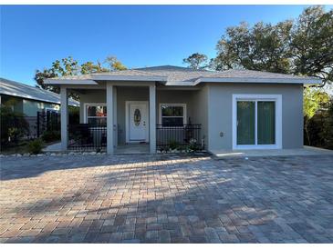 Charming home with gray exterior, covered porch, decorative door and brick paved driveway at 1534 25Th St, Sarasota, FL 34234