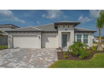 Beautiful single-story home with a three-car garage, modern architecture and a well-manicured lawn at 2015 Bolsena St, Nokomis, FL 34275