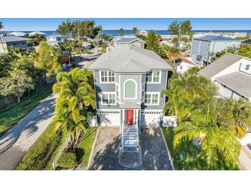 Beautiful two-story home with a brick driveway, palm trees and a view of the ocean at 2300 Avenue B, Bradenton Beach, FL 34217