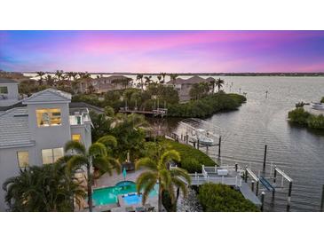 Aerial view of waterfront home with a pool, dock, and lush tropical landscaping at 4607 5Th Ne Ave, Bradenton, FL 34208