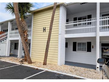 Condo exterior showing the building's facade, balconies, and landscaping with palm trees, and parking area at 1531 Pleasant Rd # H-3, Bradenton, FL 34207