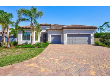 Beautiful single-Gathering home features a tile roof, well-manicured landscaping, and a brick driveway at 18115 Littleton Pl, Bradenton, FL 34202