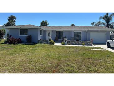 Charming single-story home with a well-maintained front yard and a cozy seating area on the porch at 22337 Olean Blvd, Port Charlotte, FL 33952