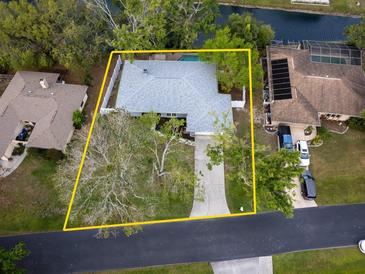 An aerial view showcases this single-Gathering home with a swimming pool and mature landscaping, outlined in yellow at 4453 Meadow Creek Cir, Sarasota, FL 34233