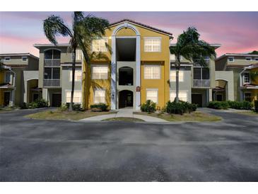 Charming condo building with colorful facade, beautiful landscaping, and bright, airy hallways at 5401 Bentgrass Dr # 1-302, Sarasota, FL 34235