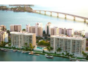Stunning aerial view of waterfront condos, lush landscaping, pool, and Sarasota Bay bridge at 550 Golden Gate Point # 201, Sarasota, FL 34236
