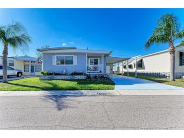Charming single-story home featuring a cozy front porch, carport and well-maintained landscaping at 5619 Bayshore Rd # 107, Palmetto, FL 34221