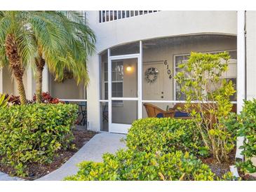 Charming screened lanai with cozy seating, lush plants, and views of the well-manicured landscaping at 6104 L Pavia Blvd # 6104, Venice, FL 34292