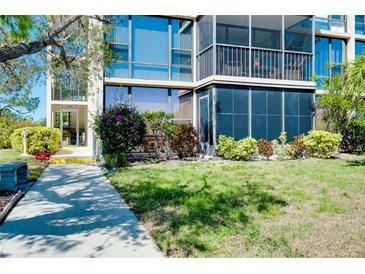 Building exterior showing lawn, garden, entry, and screened in balcony at 612 Bird Bay S Dr # 116, Venice, FL 34285