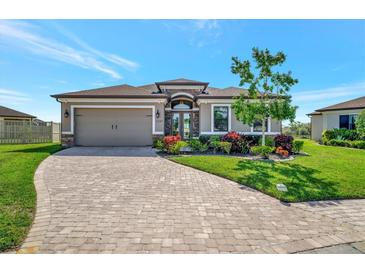 Beautiful one-story home featuring a manicured lawn and brick-paved driveway leading to a two-car garage at 6620 35Th E Ct, Sarasota, FL 34243