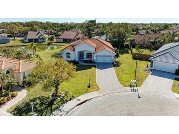 Stunning aerial view of a property with a red tile roof, surrounded by lush landscaping and a serene pond at 7102 42Nd E Ct, Sarasota, FL 34243