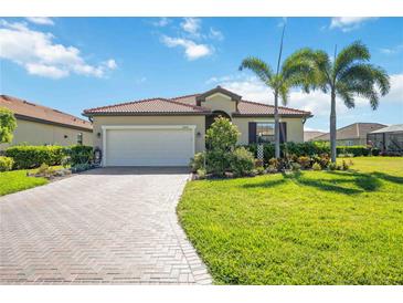 Charming single-story home featuring a tile roof, paved driveway, well-manicured lawn and beautiful landscaping at 10008 Carnoustie Pl, Bradenton, FL 34211