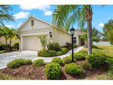 Landscaped front yard featuring a charming one-story home and driveway with an attached garage at 4954 Newport News Cir, Lakewood Ranch, FL 34211