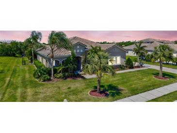 Beautiful single-story home with lush landscaping, tile roof, and a well-manicured lawn at 604 166Th E St, Bradenton, FL 34212