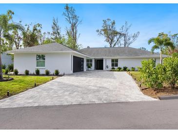 Charming single-story home with a paver driveway and manicured landscaping at 749 Tropical Cir, Sarasota, FL 34242