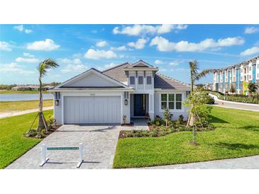 Beautiful single Gathering home with landscaped front yard, brick driveway, and attached two-car garage at 10006 Degas Ter, Bradenton, FL 34212