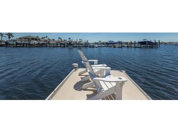 White Adirondack chairs sit at the end of a private dock with panoramic views of the surrounding boats and water at 1009 3Rd E St, Palmetto, FL 34221