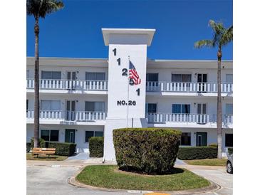 Condo building with palm trees, updated facade, and American flag waving, in a well-maintained community at 11251 80Th Ave # 305, Seminole, FL 33772