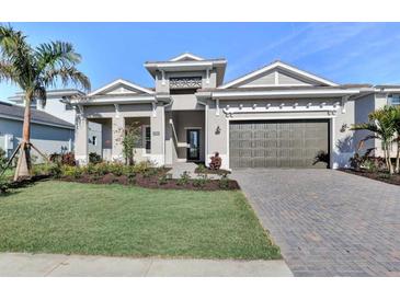 Beautiful single-story home with manicured lawn, lovely landscaping, paver driveway, and a two-car garage at 17907 Palmiste Dr, Bradenton, FL 34202